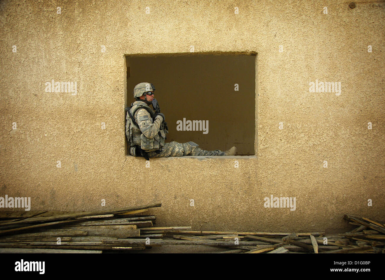 Ein Soldat der US-Armee nimmt eine Auszeit, wie er ausführt, Iraqi Workers Sanierung einer Schulhaus 17. Juli 2008 in Al Awad, Irak, 17. Juli 2008. Stockfoto