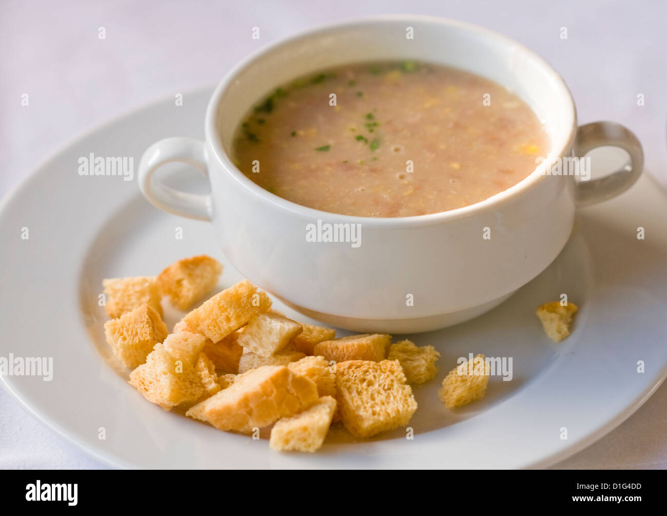 Creme Suppe serviert mit getrockneten Kruste und grün. Auf weißem Hintergrund Stockfoto
