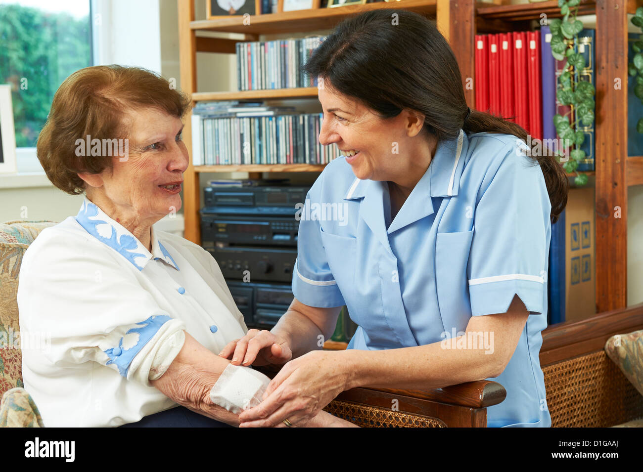 Gesundheitswesen Arbeitnehmer dressing Wunde am Arm zu Hause senior womans Stockfoto