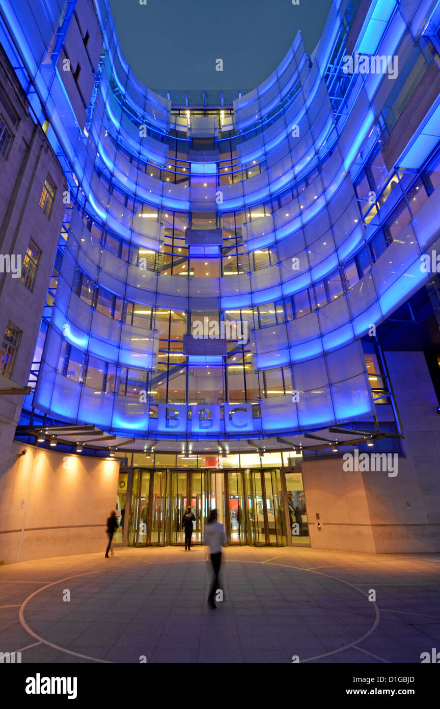 Eingang zum Broadcasting House bei Nacht mit blauer Flutbeleuchtung auf dem neuen Ostflügel-Anbau und BBC-Logo Langham Place London England UK Stockfoto