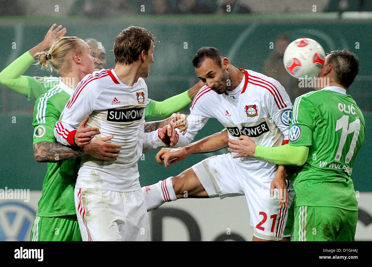 Wolfsburgs Ivica Olic (R) und Leverkusens Omer Toprak (2. R) wetteifern um die Kugel während der DFB-Pokal-Fußballspiel zwischen dem VfL Wolfsburg und Bayer Leverkusen in der Volkswagen Arena in Wolfsburg, Deutschland, 19. Dezember 2012. Foto: Peter Steffen Stockfoto