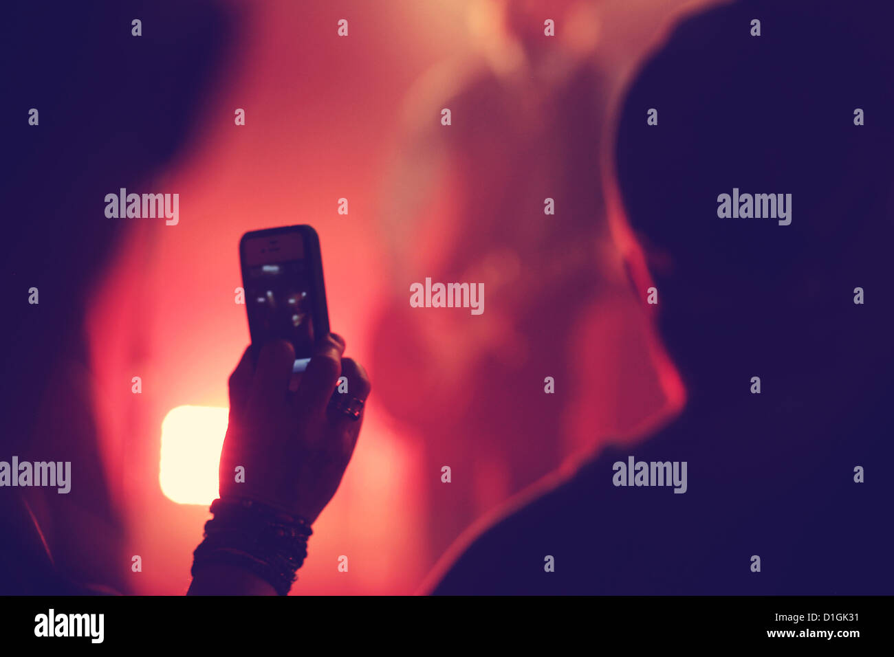 Jemand hält ein Handy bei einem Konzert ein Foto Stockfoto