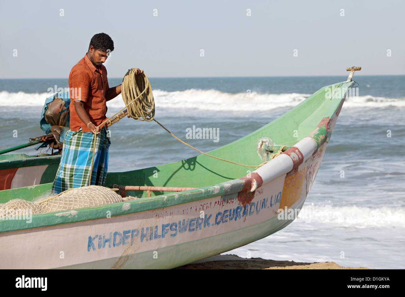 Alikuppam, Indien, ein Fischer in seinem Boot am Strand Stockfoto