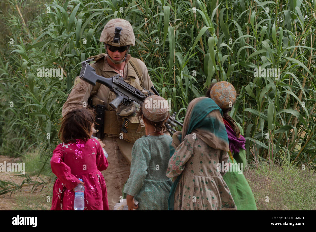 Ein US-Marine übergibt Mineralwasser afghanische Kinder während einer Patrouille 26. April 2012 in Trek Nawa, Afghanistan. Stockfoto
