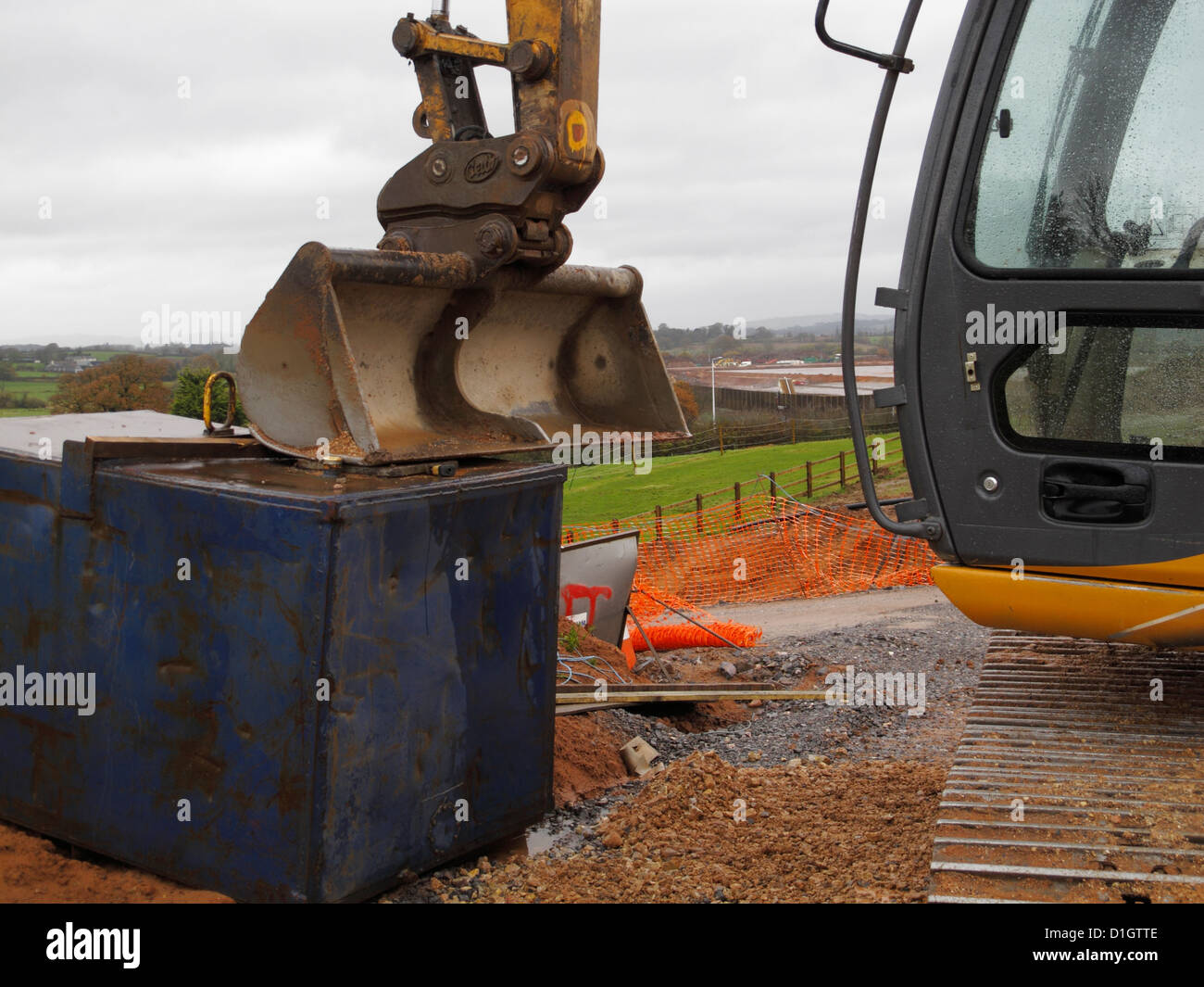 Digger Eimer ruht auf einem Tank Diesel zur Verhinderung von Diebstahl auf einer Straßenbaustelle UK. Stockfoto