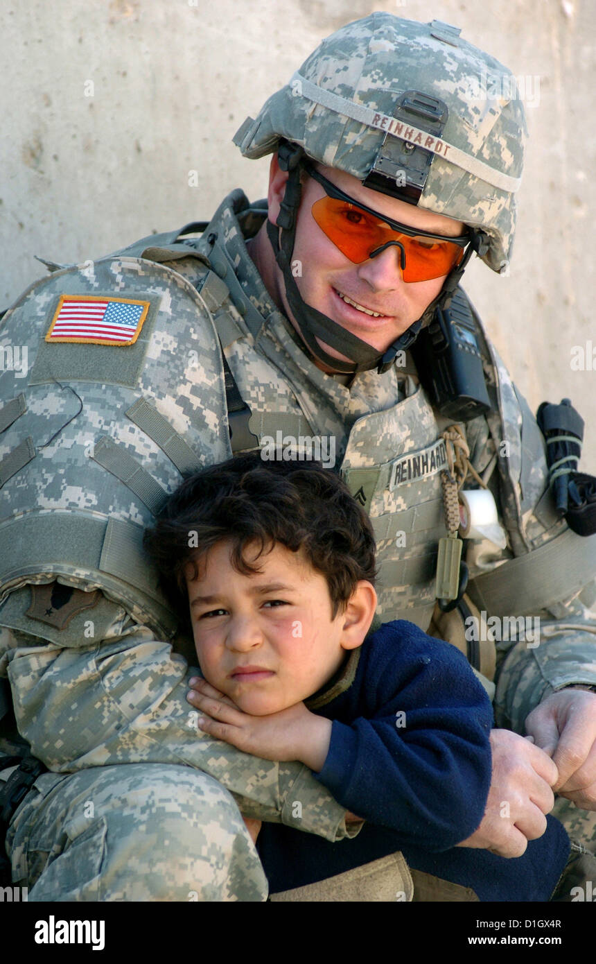 Eine irakische junge ruht auf dem Arm eines Soldaten der US Army außerhalb einer irakischen Polizei-Abteilung in Bagdad, Irak 12. März 2006. Stockfoto