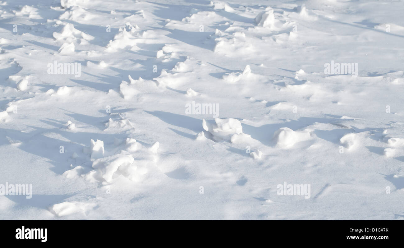 Textur des scharfen hügeligen Schneewehe mit schönen Schatten Stockfoto