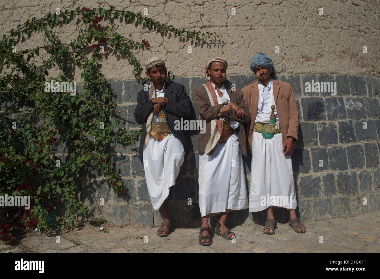 drei Männer kauen Khat vor Bab Al Yeman Tor vor der alten Stadt Stockfoto