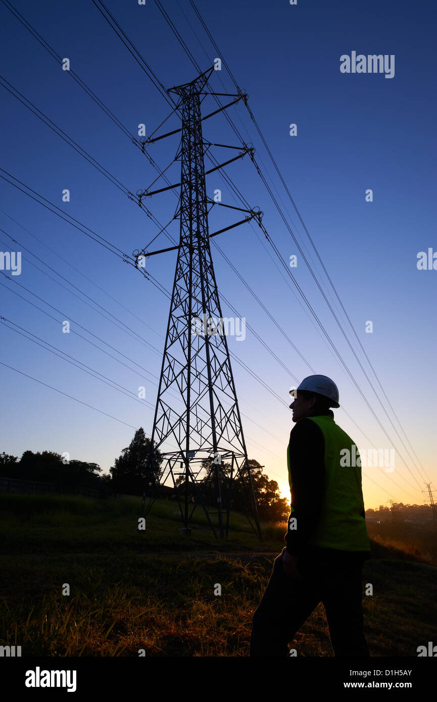 Silhouette Strommasten und Arbeiter in Schutzhelm Stockfoto