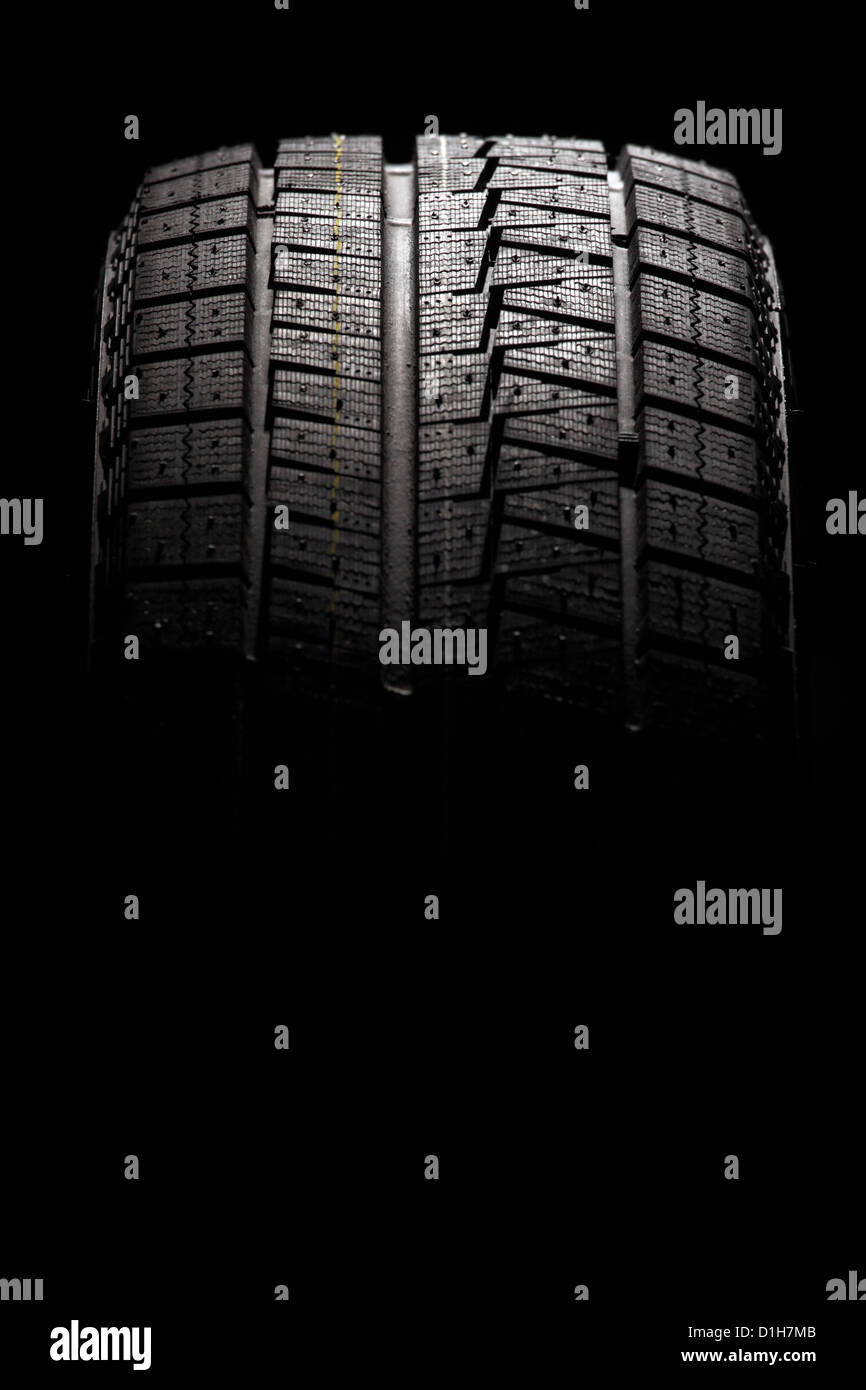 Moderne Winter-Performance-Reifen. Auf schwarzem Hintergrund isoliert. Vertikale Zusammensetzung. Stockfoto