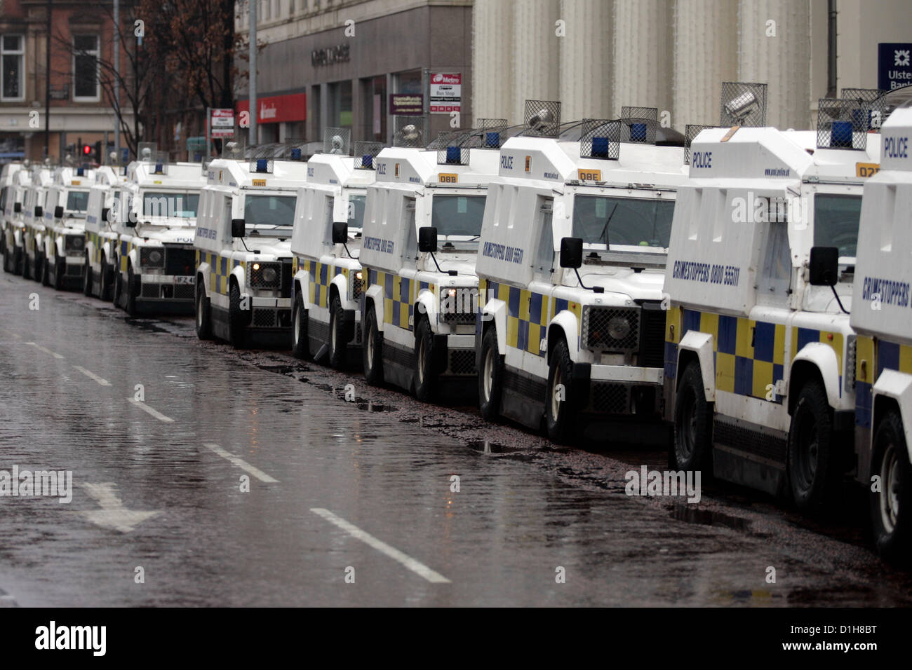 Eine Reihe von PSNI Landrover nach Belfast City Rat gestimmt, nur die Union Jack fliegen über Belfast City Hall für 17 Tage pro Jahr. Menschen aus der Evangelischen Gemeinschaft blockieren Straßen und Holding Protest über die Provinz Nordirland. Heute wurde außerhalb von Belfast City Hall, wo Menschen versammelt, Halten oder Tragen Union Jack Fahnen. Bonzo/Alamy leben Nachrichten Stockfoto