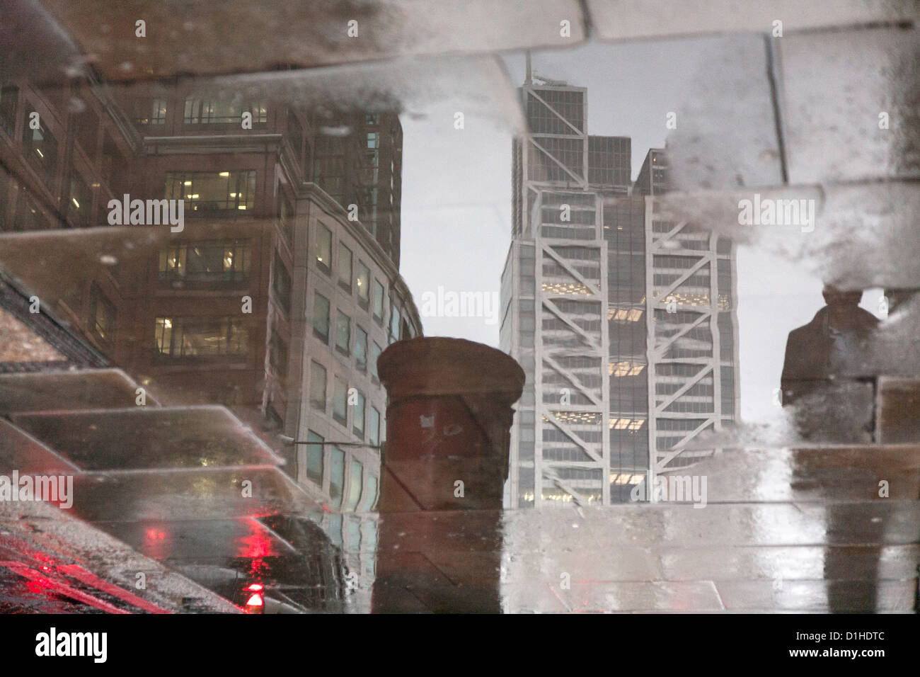 Reflexion der Heron-Tower in Pflaster Pfütze an einem regnerischen Tag in der City of London Stockfoto