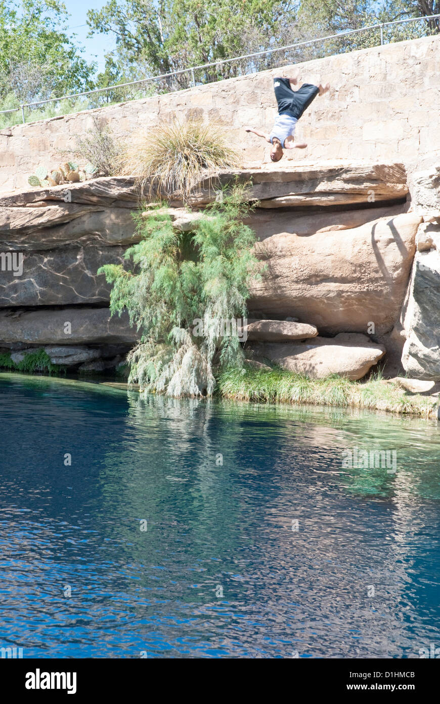 Ein Taucher taucht rückwärts aus einem Felsvorsprung am berühmten Blue Hole in Santa Rosa, New Mexico. Stockfoto