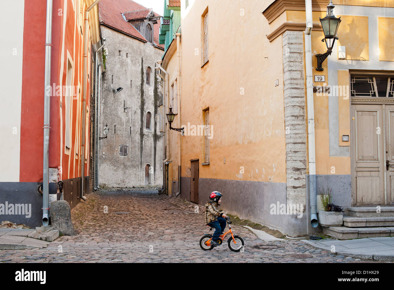 Ein Kleinkind auf dem Fahrrad in Lai-Straße in der Altstadt von Tallinn, der Hauptstadt von Estland. Stockfoto