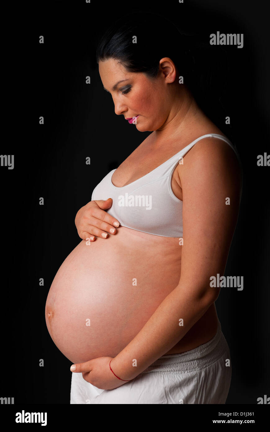 Schwangeren Bauch zu berühren und blickte in die Dunkelheit Stockfoto