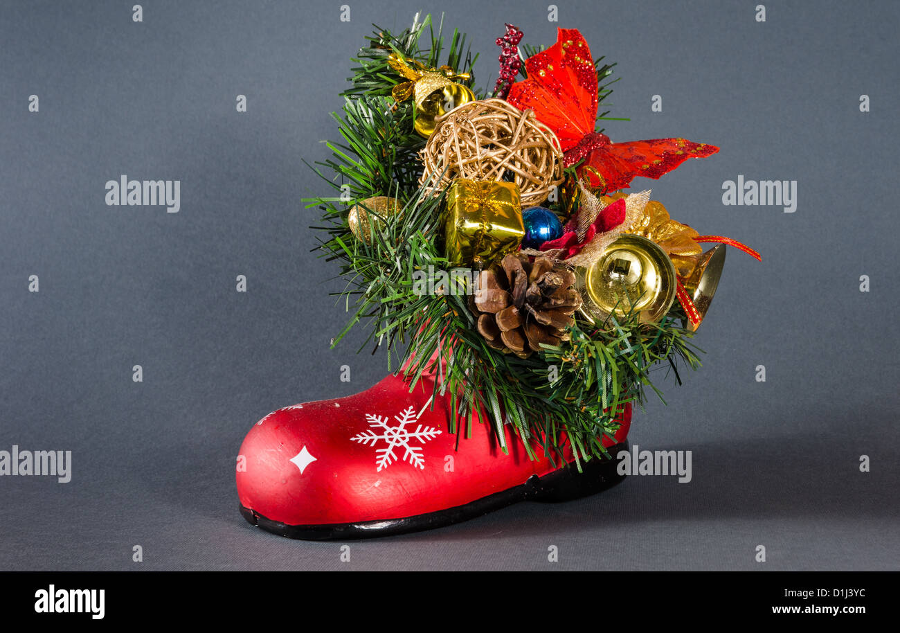 Weihnachtsdekoration-Boot mit Glocken, Tannenzapfen und Geschenkkartons Stockfoto