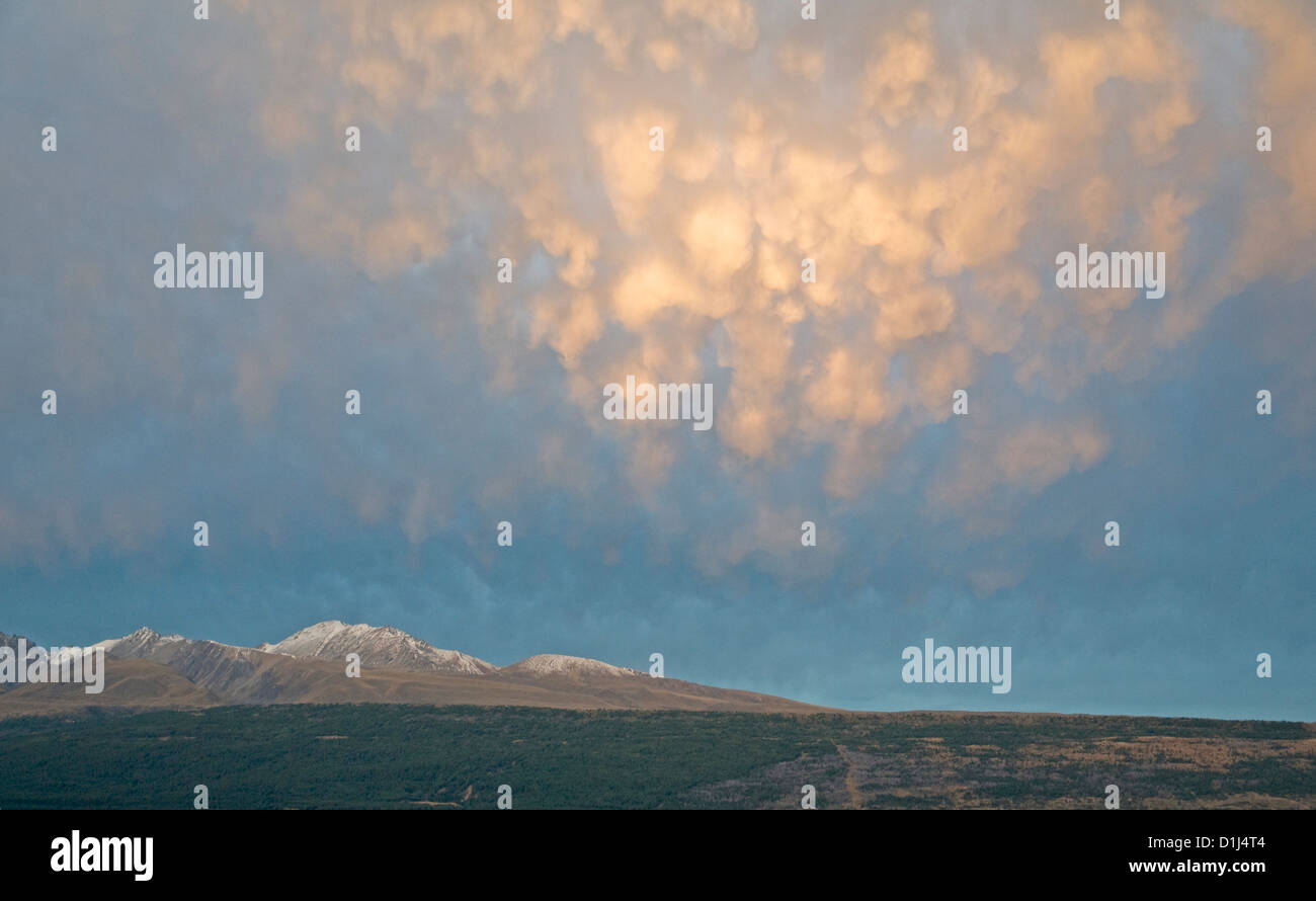 Anzeige bei Sonnenuntergang als Mammatus Wolke fällt durch die tiefstehende Sonne, Blick nach Osten von Glentanner Station, New Zealand beleuchtet Stockfoto