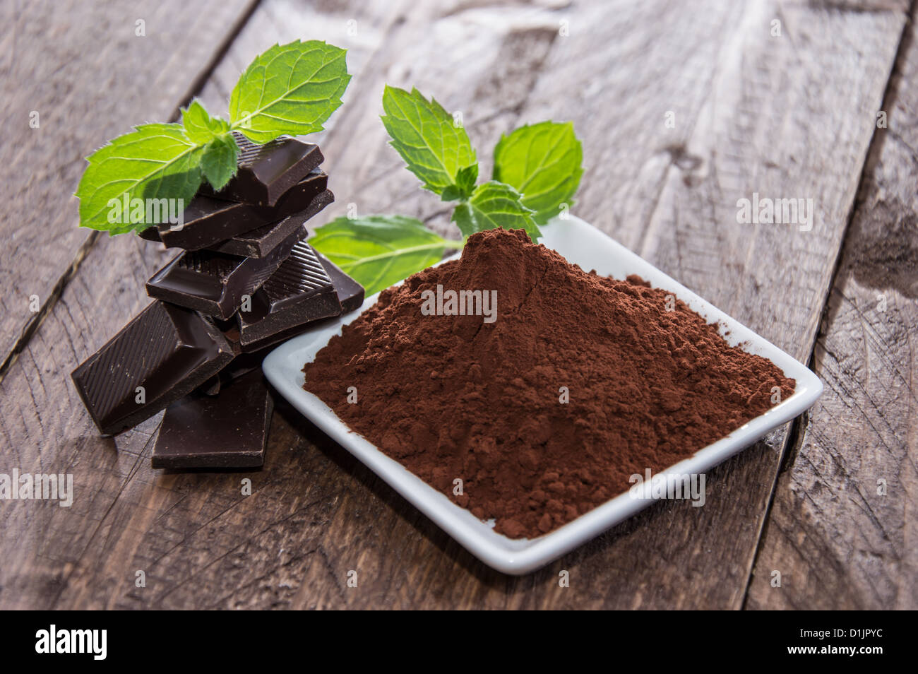 Schokolade mit einem Haufen von Kakao auf hölzernen Hintergrund Stockfoto