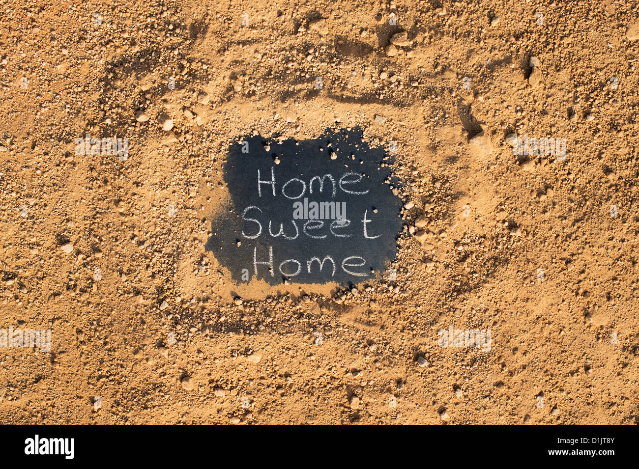 Tafel mit HOME SWEET HOME geschrieben steht auf einem Feldweg. Indien Stockfoto