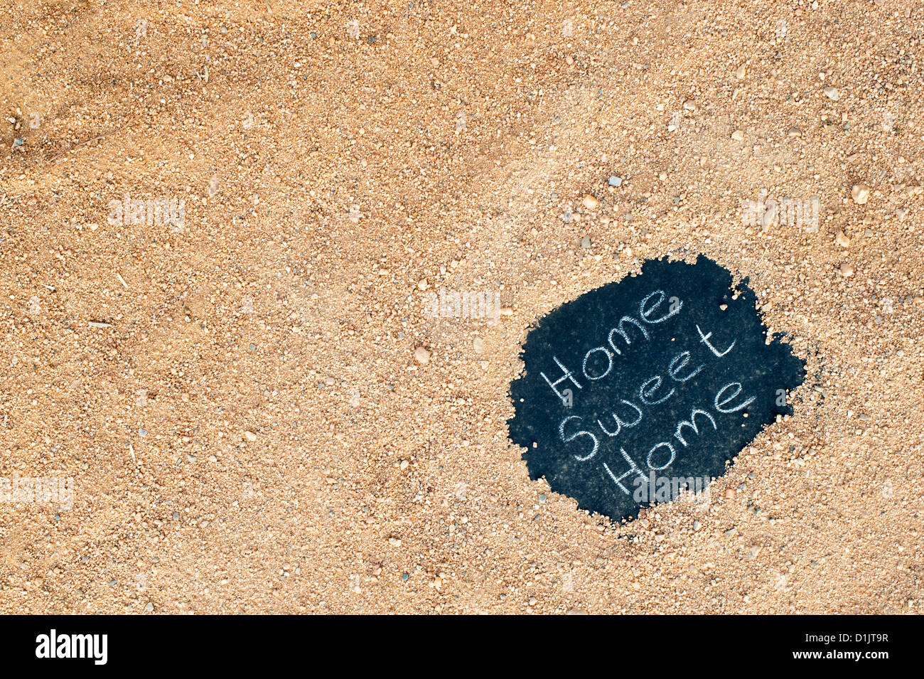 Tafel mit HOME SWEET HOME geschrieben steht auf einem Feldweg. Indien Stockfoto