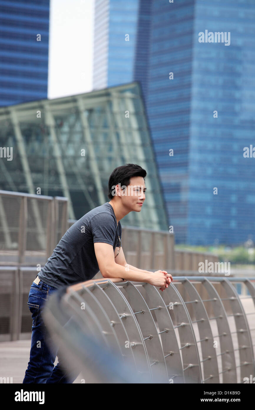 Profil von junger Mann stützte sich auf Geländer in der Ansicht Stockfoto