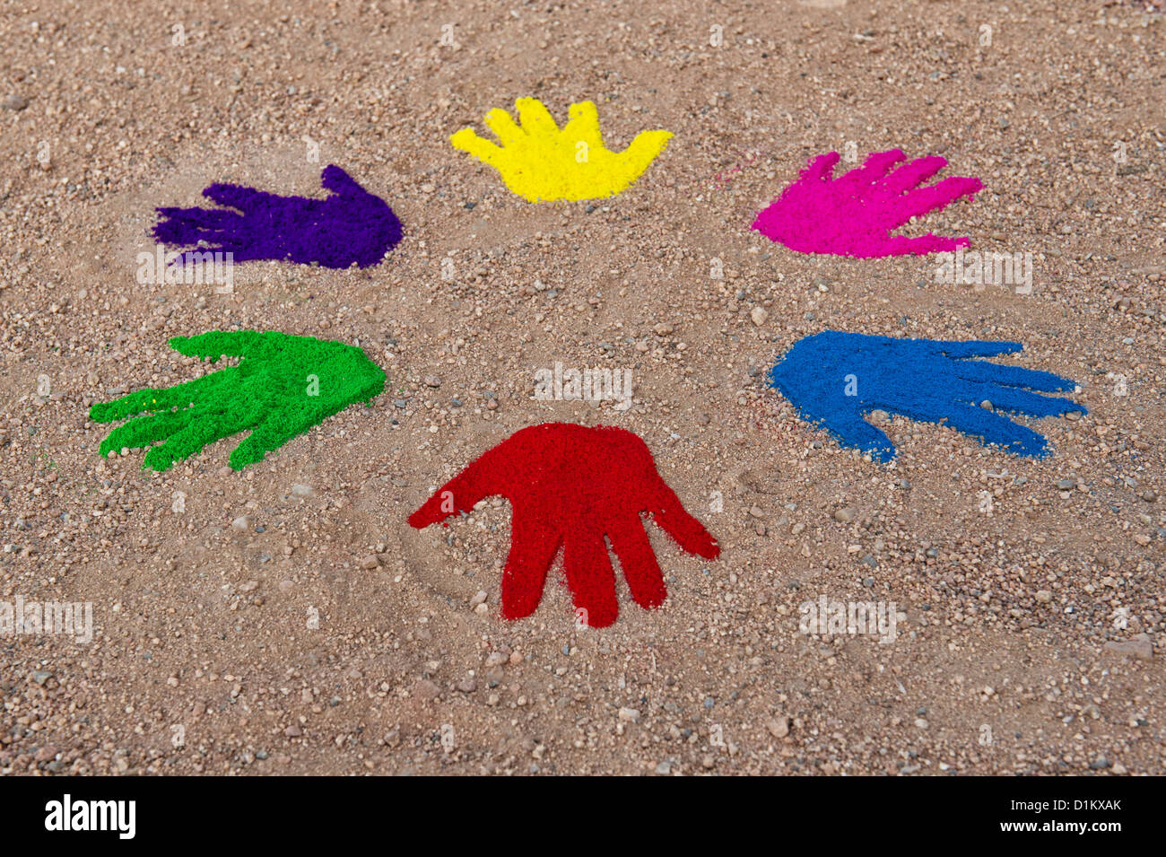 Farbige Pulver Handabdrücke in einem kreisförmigen Muster auf einem Feldweg Stockfoto