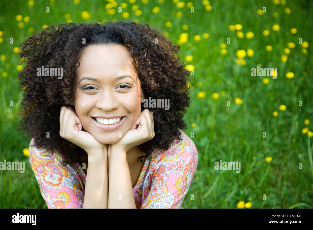 Lächelnde Hispanic Frau mit Kopf in Händen Stockfoto