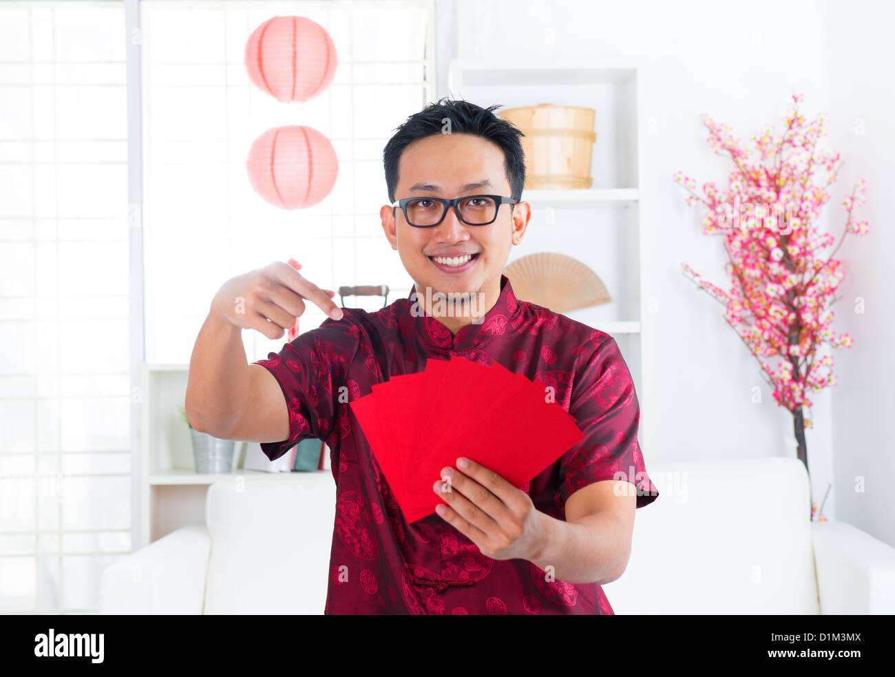 Southeast Asian chinesische Mann zeigte bei vielen rot-Pakete / Ang pow im Innenbereich Stockfoto