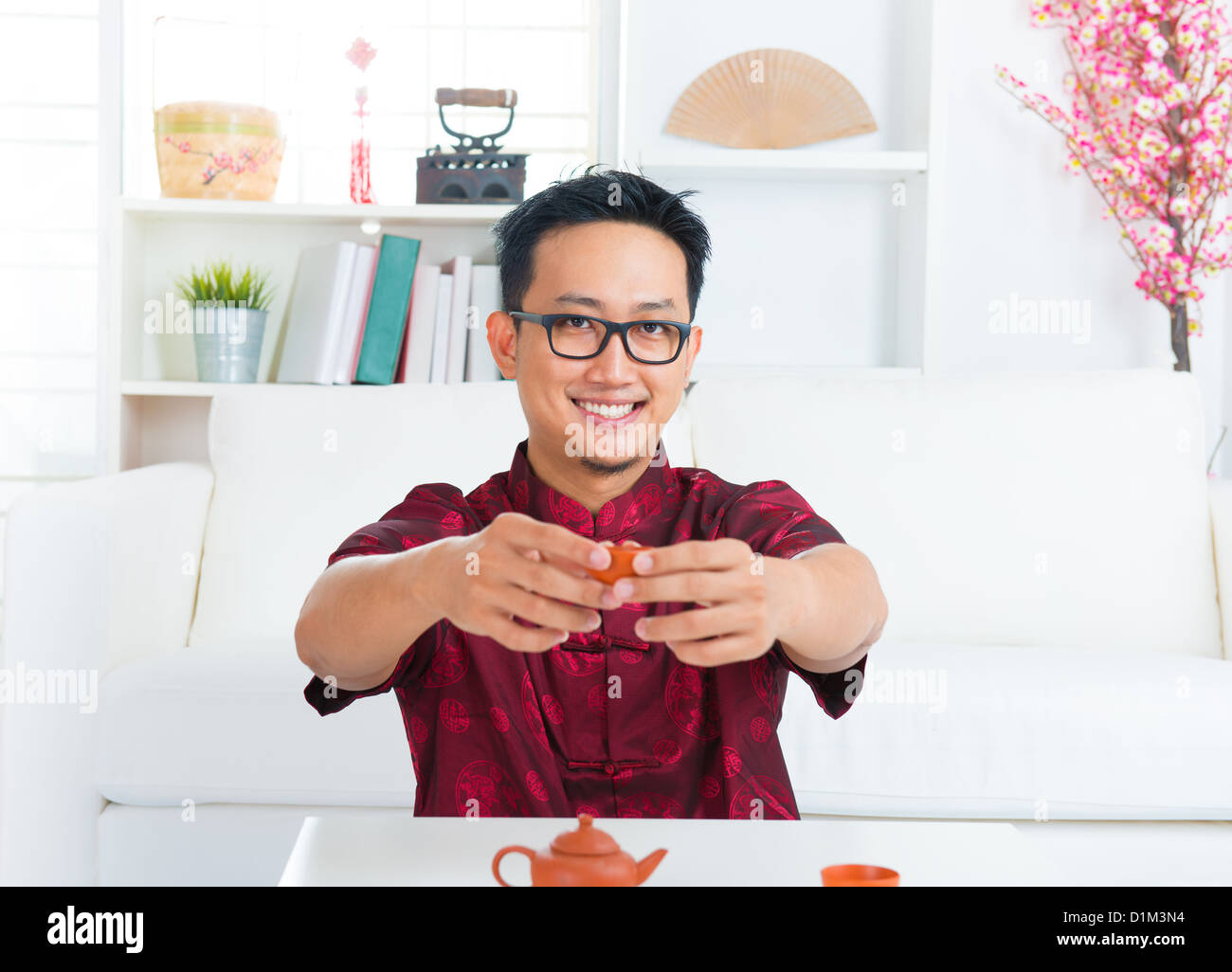 Southeast Asian Chinese Mann Betrieb Teetasse im Innenbereich Stockfoto