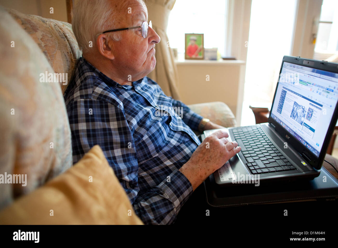 Älterer Mann mit einem Laptop-Computer zu Hause Stockfoto
