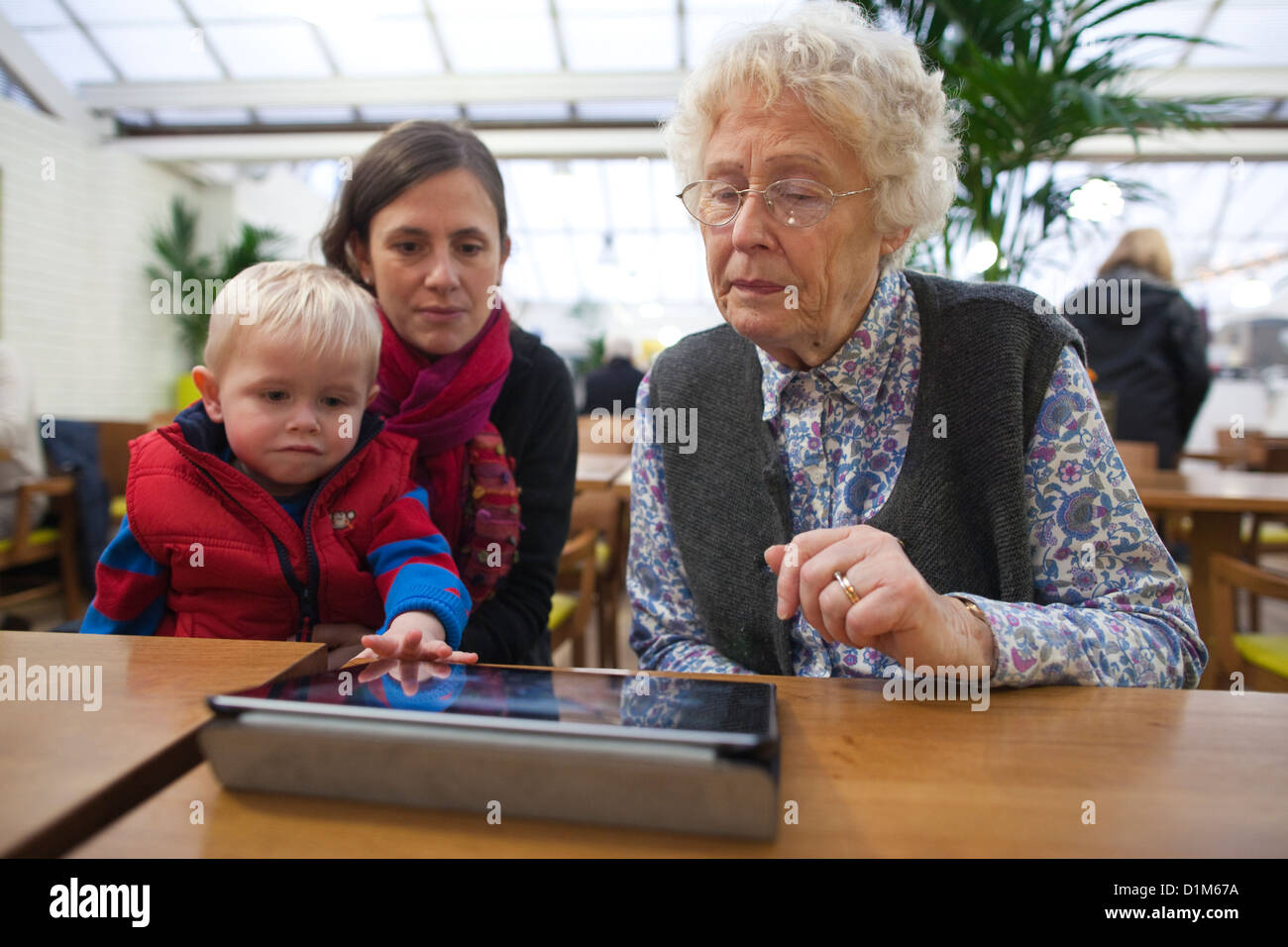 Großmutter, die mit ihrem Enkel einen Tablet-Computer benutzt, England, Vereinigtes Königreich Stockfoto