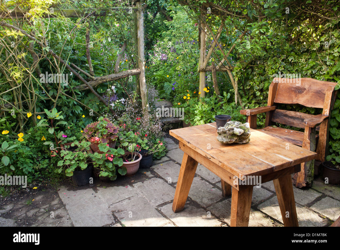 Relax-Bereich auf einer Terrasse mit rustikalen Gartenmöbeln. Stockfoto