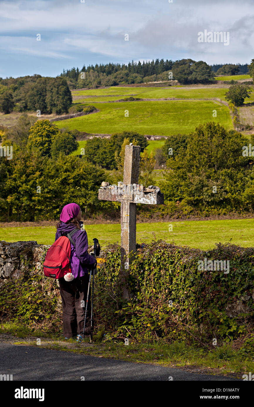 Pilger-Backpacker hält für einen Moment der Stille am Kreuz, einem Wallfahrtsort entlang der Weise von St. James Galizien Spanien Stockfoto