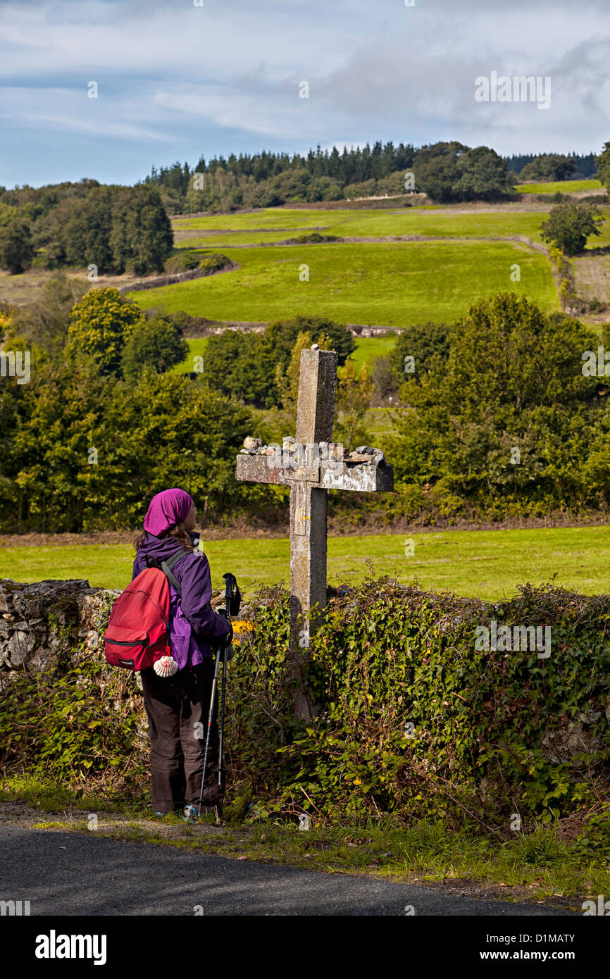 Pilger-Backpacker hält für einen Moment der Stille am Kreuz, einem Wallfahrtsort entlang der Weise von St. James Galizien Spanien Stockfoto