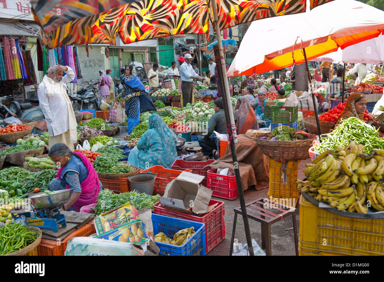 Eine bunte Obst- und Gemüsemarkt in Indien mit lokalen indischen Männern und Frauen an einem sonnigen Tag kaufen und verkaufen Stockfoto