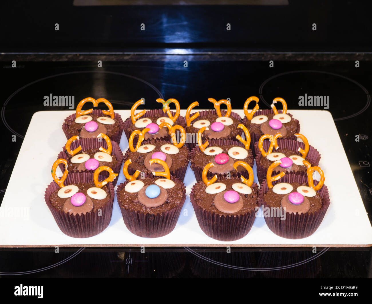Ein Tablett mit Schokolade Feenkuchen mit lustigen Gesichtern gemacht mit Schokolinsen Stockfoto