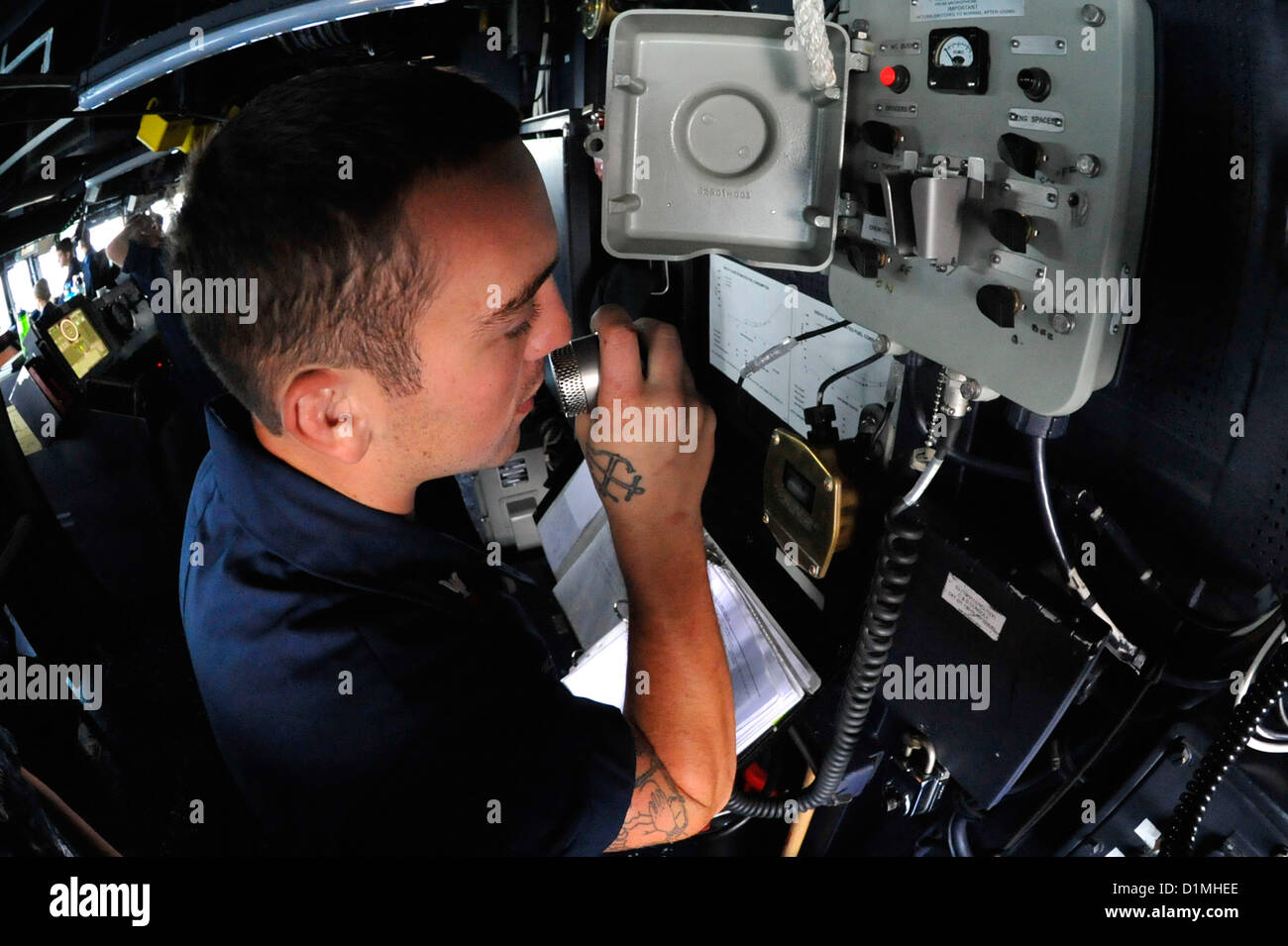 Der Bootsmann Mate 2. Klasse Drew Miller geht das Wort für grünen Deck über das Schiff allgemeine Ankündigung System im Flugbetrieb an Bord der geführte Flugkörper-Zerstörer USS Jason Dunham (DDG-109). Jason Dunham mit John C. Stennis Strike Group in den USA bereitgestellt wird 5. Flotte Aufgabengebiet Durchführung von maritimer Sicherheitsoperationen, Theater Sicherheitsbemühungen Zusammenarbeit und Unterstützung Missionen für die Operation Enduring Freedom. . Arabisches Meer (Dec.29, 2012) U.S. Navy Photo Stockfoto