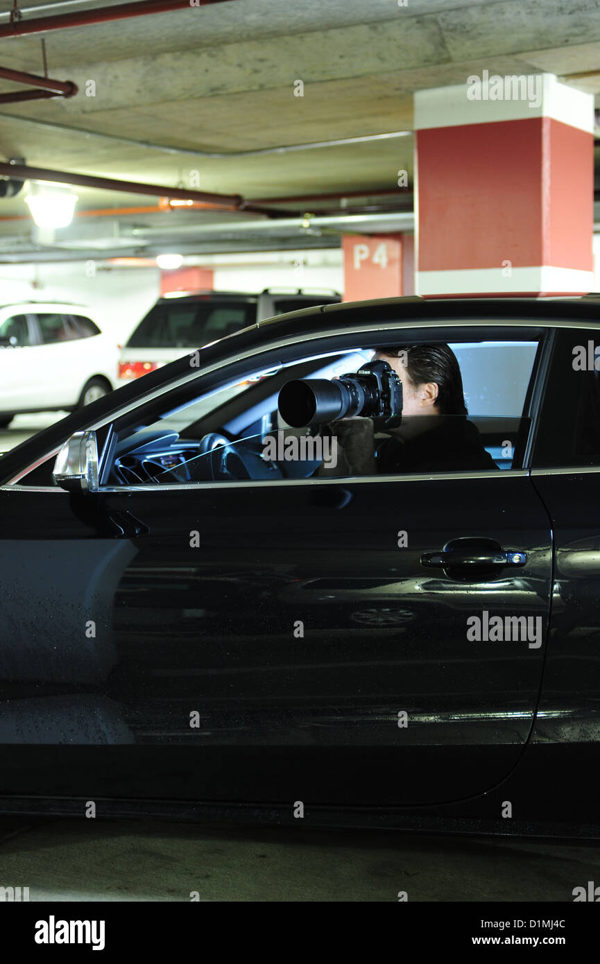 Privatauge oder Privatdetektiv Ermittler im Auto mit Kamera Jemandem heimlich folgen Stockfoto