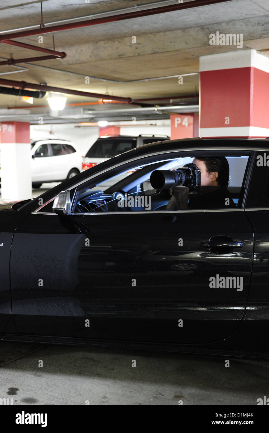Privatauge oder Privatdetektiv Ermittler im Auto mit Kamera Jemandem heimlich folgen Stockfoto
