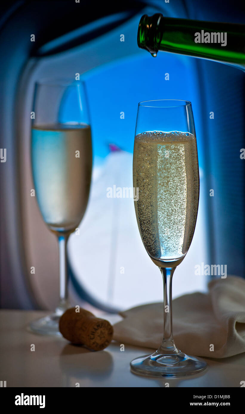 Frisch gezapftes französischen Champagner während des Fluges in Luxus-Kabine mit Fenster und Flugzeug Flügel hinter Stockfoto
