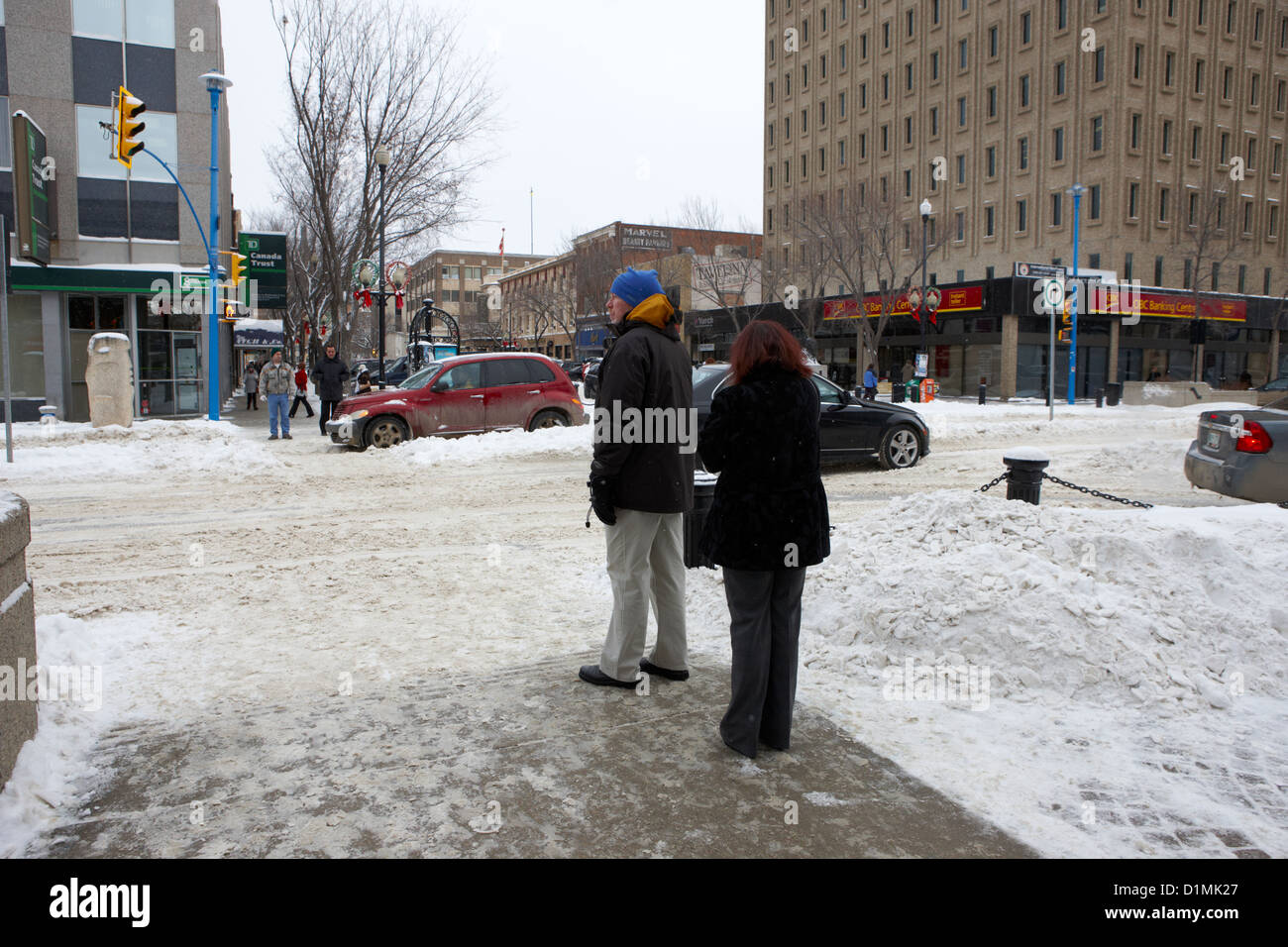 wartenden nachzutun Schnee bedeckt Kreuzung Zebrastreifen Stadt Straße Saskatoon Saskatchewan Kanada Stockfoto