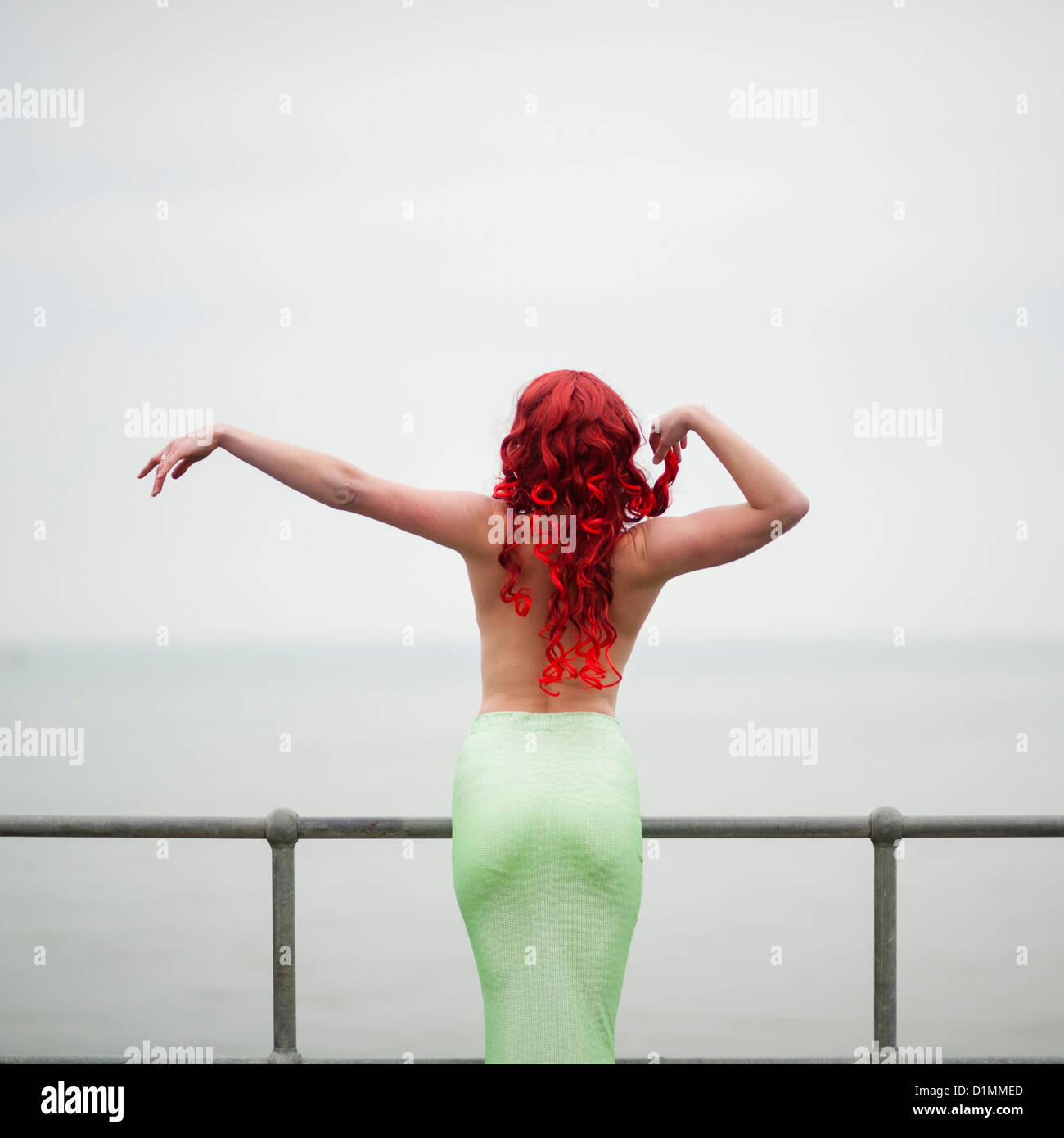 Hinten Rückansicht von Chloe Loftus, Tänzerin, gekleidet wie eine Meerjungfrau, Outdoor-Performance-Kunst, UK Stockfoto