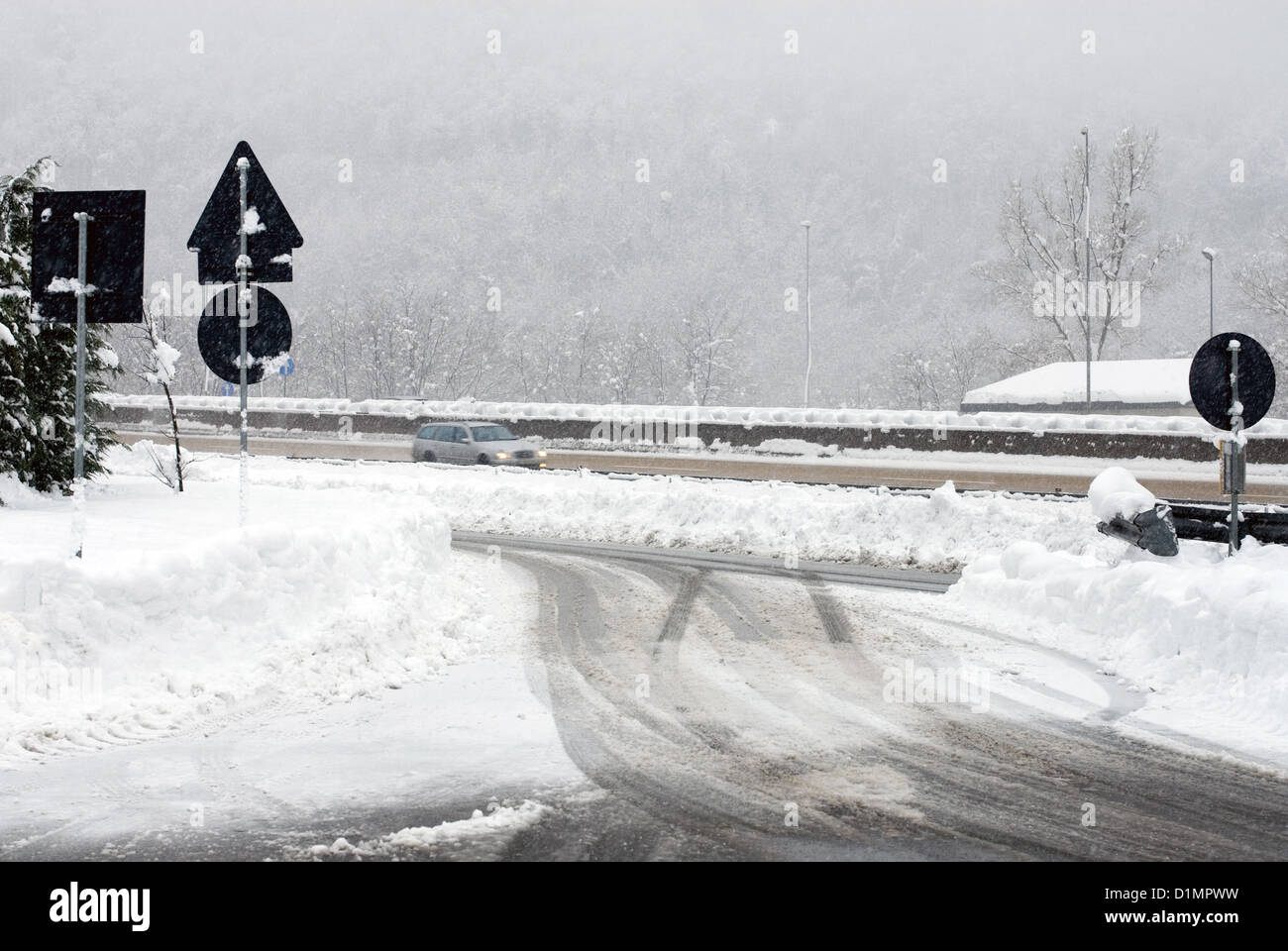 Ein Auto fährt ein Dienst beendet auf eine italienische Autostrada während eines Schneesturms Vergangenheit Stockfoto