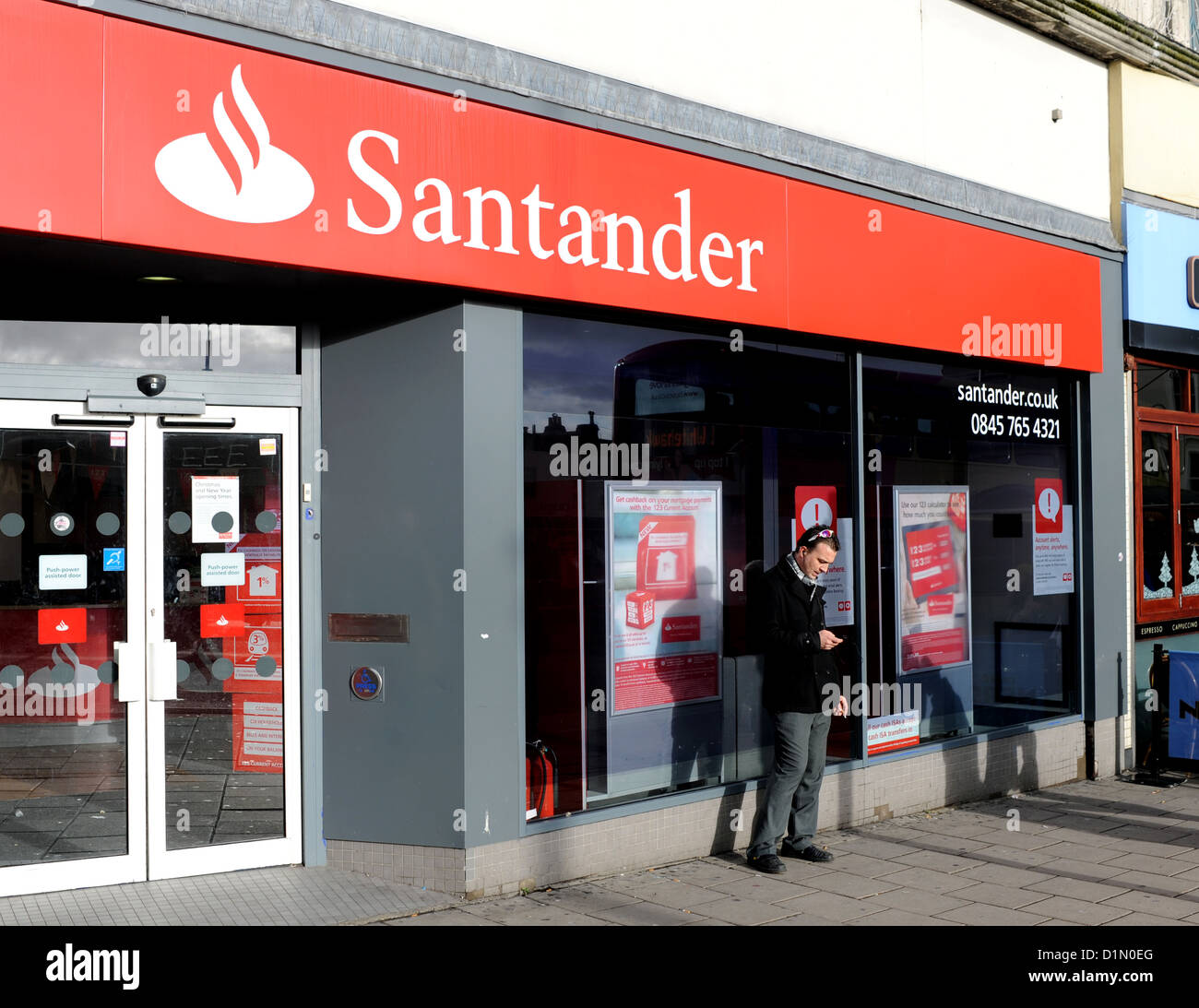 Mann mit Handy vor einer Santander Bank in Brighton UK Stockfoto