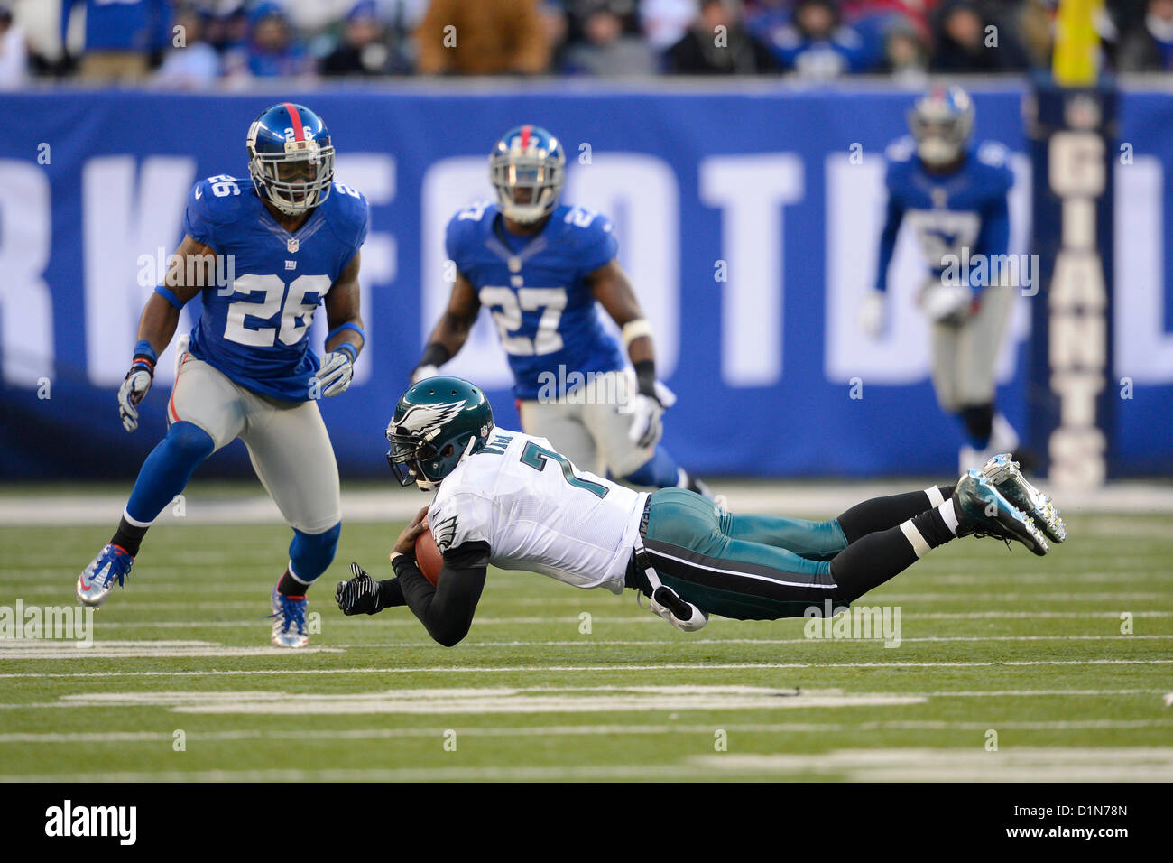 New Jersey, USA. 30. Dezember 2012: Philadelphia Eagles-quarterback Michael Vick (7) Tauchgänge vor der New York Giants kostenlosen Sicherheits Antrel Rolle (26) während einer Woche 17 NFL Matchup zwischen der Philadelphia Eagles und die New York Giants im MetLife Stadium in East Rutherford, New Jersey. Die Riesen besiegt die Eagles 42-7. Stockfoto