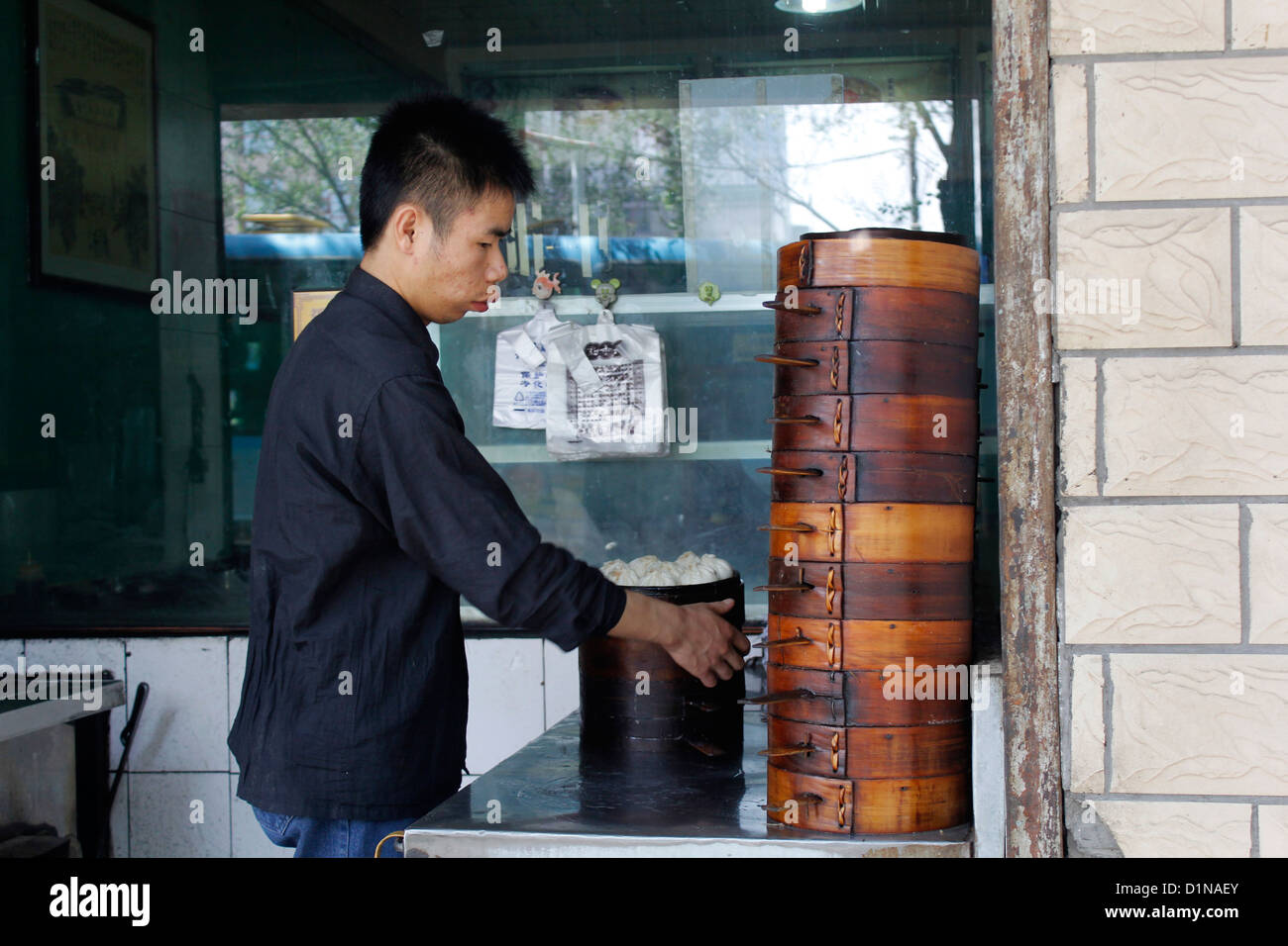 ein chinesischer Mann die traditionelle chinesische Küche Dim-Sum (Knödel) in Bambuskörben Dampfer Stockfoto