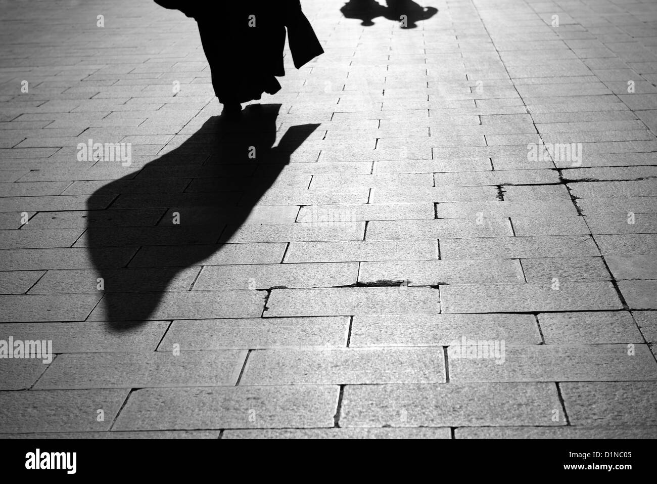 Schatten von einer muslimischen Frau und zwei Männer gehen über die Eyüp Sultan Boulevard Istanbul Türkei Stockfoto