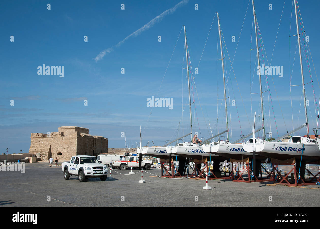 Erste Unternehmen J 80 Yachten zu segeln, auf dem Kai in Paphos Zypern mit einer Kulisse der mittelalterlichen Festung Stockfoto