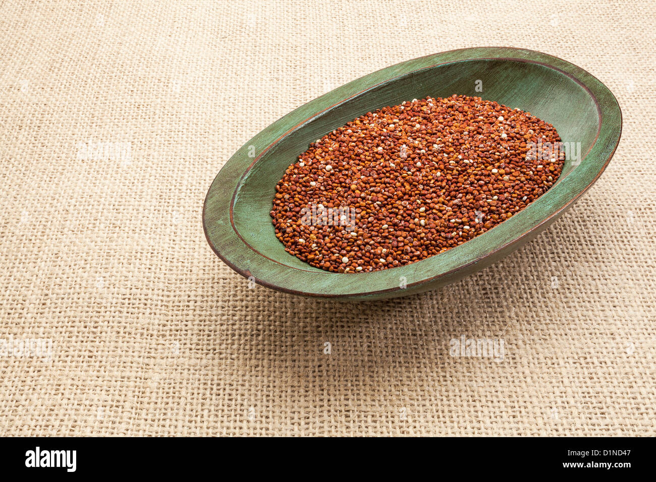 canvas-rote Quinoa Getreide in einer rustikalen Holz Schüssel gegen Sackleinen Stockfoto