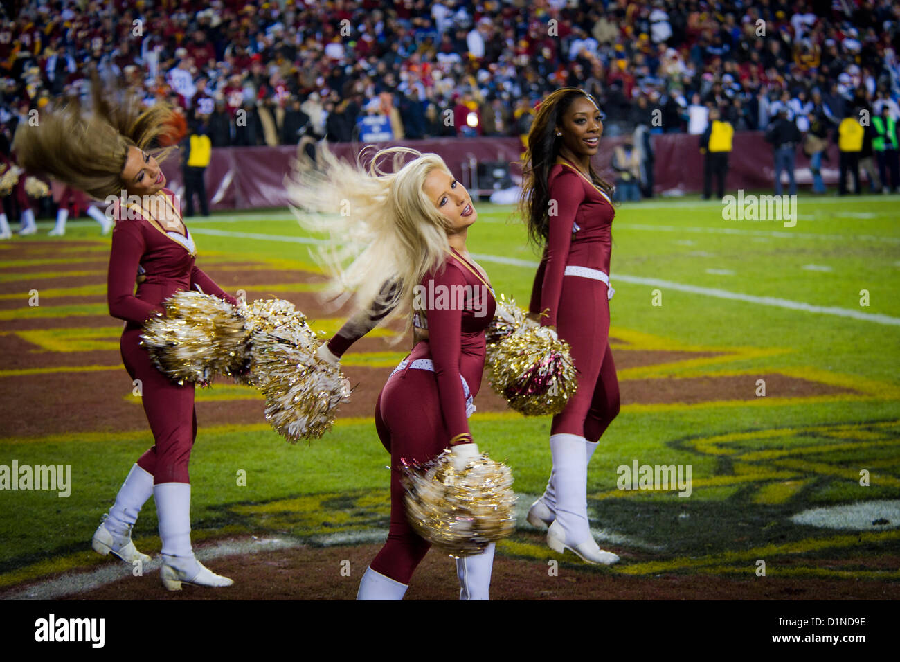 Nachdem die Truppen für ihren Dienst geehrt wurden, treten die Washington Redskins Cheerleader während des NFL-Spiels zwischen den Washington Redskins und den Dallas Cowboys im FedEx Field, Landover, Maryland auf. Die Redskins gewannen 28-18 und erreichten die Playoffs vor über 82.000 Zuschauern. Die Truppen wurden von der USAA für ihren Dienst während der Veranstaltung geehrt. Stockfoto
